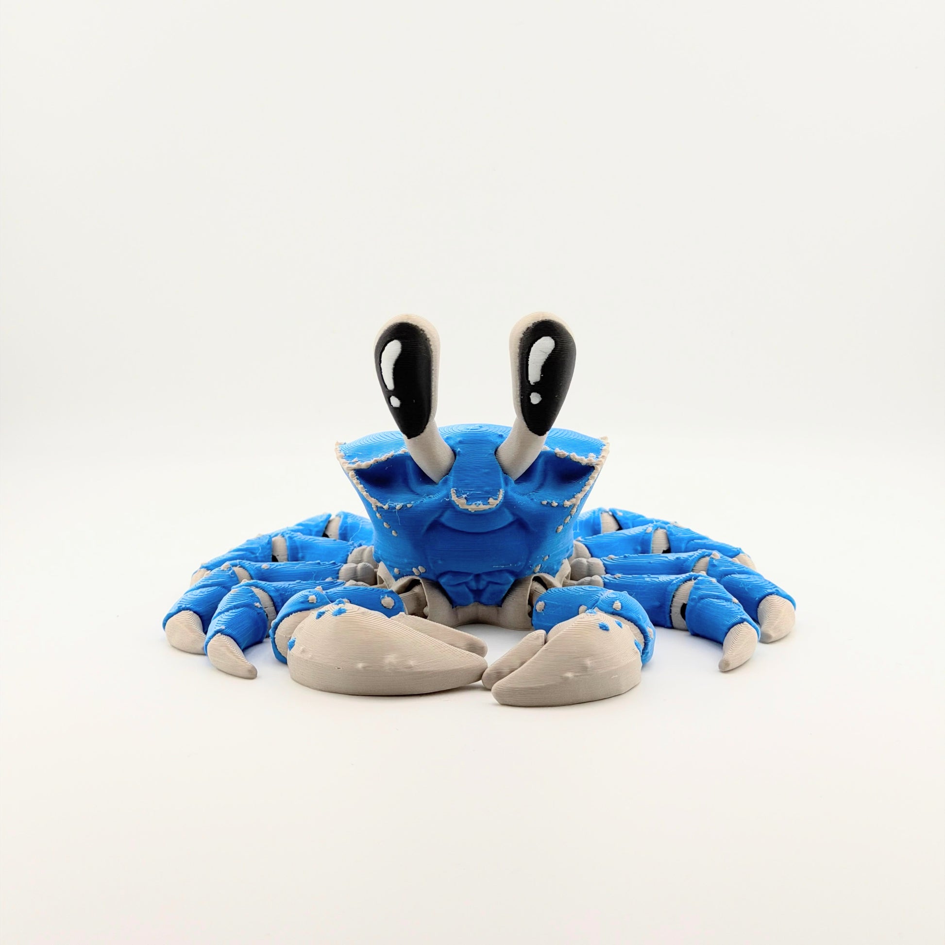 Blue articulated 3D printed ghost crab facing forward on a white background.